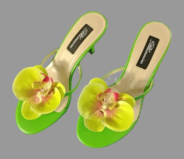 Green sandals with floral design on a blue background